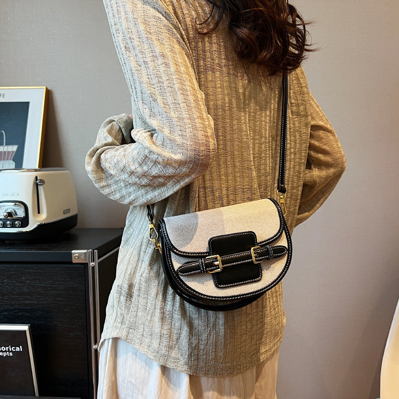 Small handbag with black leather accents on a white background